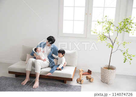 赤ちゃんのお世話をする若いお父さん(パパ)とまだ幼いお兄ちゃん 赤ちゃんのお世話をする若いお父さん(パパ)とまだ幼いお兄ちゃん 114074726