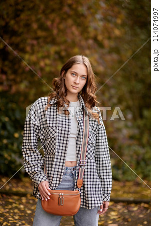 Autumn Elegance: Girl with Warm Tones, Casual Style, and a Park Stroll. Autumn Woman Portrait. Beauty Fashion Model Girl with Autumnal Make up and Hair style. Fall. Creative Autumn Makeup. Beautiful Autumn Elegance: Girl with Warm Tones, Casual Style, and a Park Stroll. Autumn Woman Portrait. Beauty Fashion Model Girl with Autumnal Make up and Hair style. Fall. Creative Autumn Makeup. Beautiful 114074997
