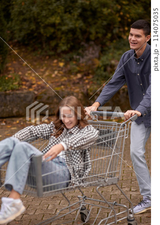 Autumn Joyride: Boy Rolling Girl in Shopping Cart amid Nature's Beauty. Teen Love's Autumn Frolic: Boy Rolling Girlfriend in a Shopping Cart Autumn Joyride: Boy Rolling Girl in Shopping Cart amid Nature's Beauty. Teen Love's Autumn Frolic: Boy Rolling Girlfriend in a Shopping Cart 114075035