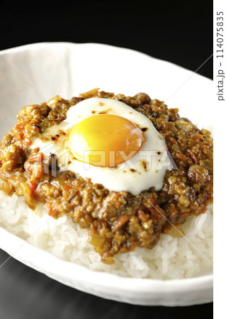 卵黄、焦がしチーズ乗せキーマカレーを黒背景で撮影 114075835