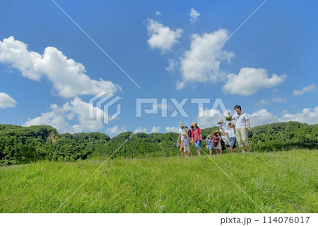 夏の草地を歩く行楽の2家族 114076017