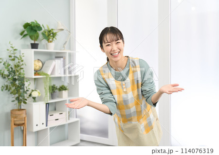 歓迎をするエプロンを着た女性 114076319