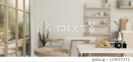 A table with decor in a minimalist contemporary coffee shop or restaurant. A table with decor in a minimalist contemporary coffee shop or restaurant. 114077371
