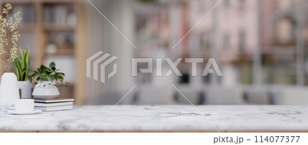 A white marble table against a blurred background of a living room. A white marble table against a blurred background of a living room. 114077377