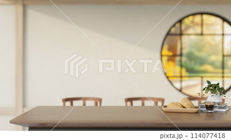 A wooden dining table in a contemporary traditional Japanese dining room features a round window. 114077418