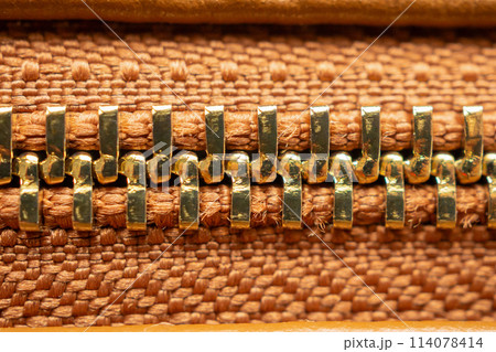 close up of zipper on brown leather bag 114078414