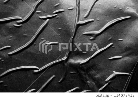 black crumpled and creased plastic poster texture background 114078415