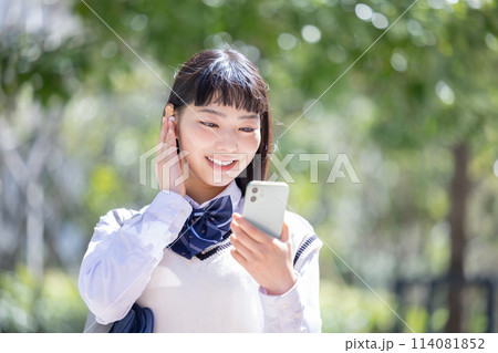 イヤホンをしてスマホを見ている女子高生 イヤホンをしてスマホを見ている女子高生 114081852