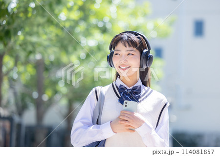 ヘッドフォンをしてスマホを持っている女子高生 ヘッドフォンをしてスマホを持っている女子高生 114081857