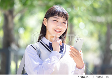 イヤホンを付けてスマホを見ている女子高校生 イヤホンを付けてスマホを見ている女子高校生 114081940