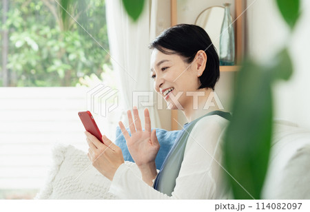 リビングでスマートフォンを操作する主婦 114082097