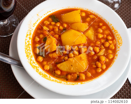 Stew boiled soup prepare of cod fillet, potatoes, chickpeas in tomato sauce. 114082610