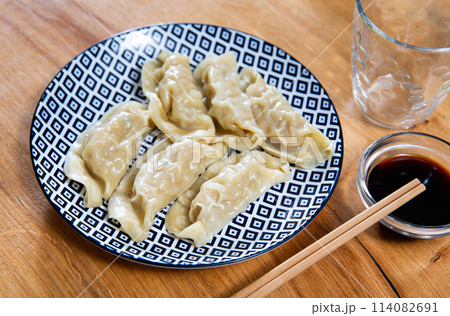 Boiled Yaki Gyoza served in plate with special sauce and chopsticks 114082691