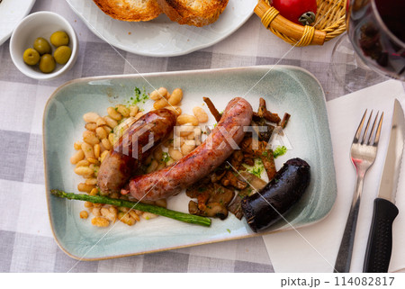 Catalan dish with baked sausages, fried beans, mushrooms and asparagus 114082817