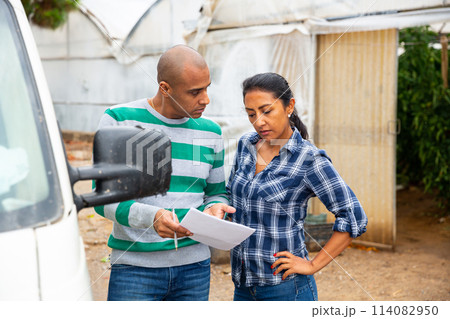 Farmer and freight forwarder sign documents for shipment in the courtyard 114082950