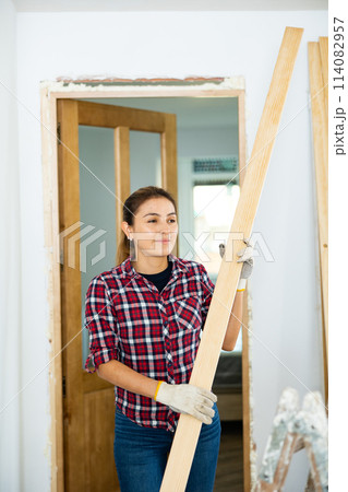 Woman prepares place to install door in doorway 114082957