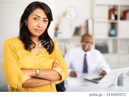 Successful hispanic business woman with arms crossed in office 114083072