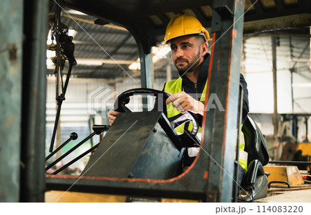forklift driver sits in his vehicle in a warehouse and gives a thumbs up to show confidence in his work 114083220