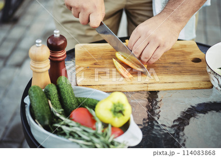 Unrecognizable man slicing sweet bell pepper for salad 114083868