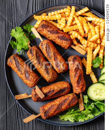 minced beef skewers with potato fries on plate 114084539