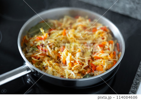 Spanish dish with cabbage and pepper for lunch in frying pan Spanish dish with cabbage and pepper for lunch in frying pan 114084686