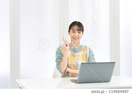 パソコン作業で良いことを思いつくエプロンを着た女性 パソコン作業で良いことを思いつくエプロンを着た女性 114084997