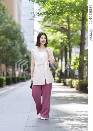 街を歩く笑顔の30代の女性 街を歩く笑顔の30代の女性 114086886