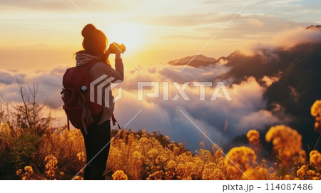 Sightseer with camera, beautiful sunrise mountain and sea of fog during golden hour. Generative AI 114087486