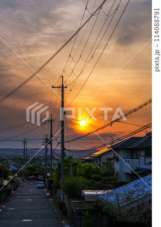 初夏奈良市の住宅街に沈む夕日 黄金色に染まる夕焼け空と街並み 初夏奈良市の住宅街に沈む夕日 黄金色に染まる夕焼け空と街並み 114088791