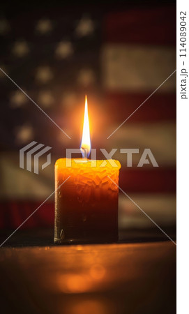 The warm light of a candle reflects the solemnity of Memorial Day against an unfocused American flag. The warm light of a candle reflects the solemnity of Memorial Day against an unfocused American flag. 114089042