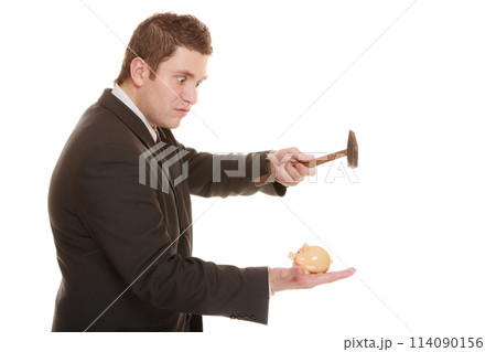 Business man with hammer about to smash piggy bank Business man with hammer about to smash piggy bank 114090156