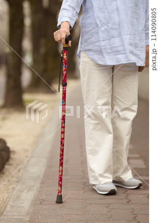 杖を持つミドル女性の手元 114090805
