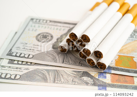 Cigarette on US dollar banknotes, cost, trading, marketing and production, No smoking. Cigarette on US dollar banknotes, cost, trading, marketing and production, No smoking. 114093242