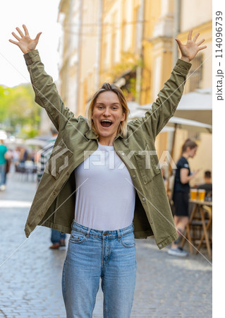 Happy woman showing thumbs up like sign positive something good positive feedback on city street 114096739