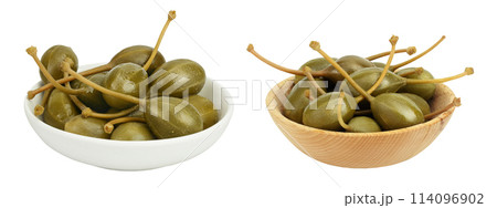 Capers in ceramic and wooden bowl isolated on white background. Pickled or canned capers. Capers in ceramic and wooden bowl isolated on white background. Pickled or canned capers. 114096902