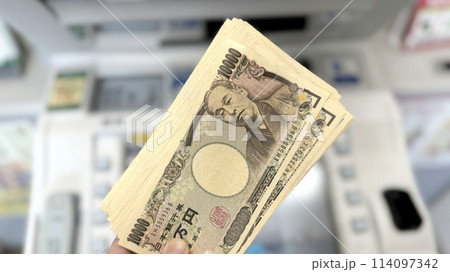 ATMの前で持ったたくさんの1万円札_ワイド 114097342