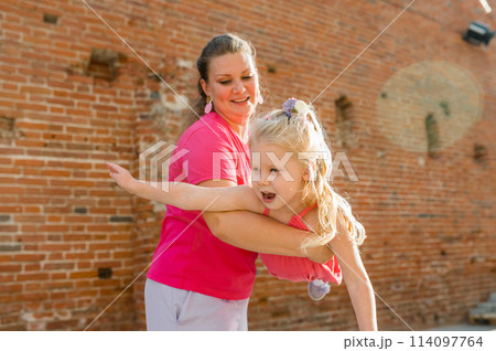Child girl with cochlear implant with her mother spend time outdoor. Hear impairment and deaf community concept. Deaf and health concept. Disability and inclusion. Copy space Child girl with cochlear implant with her mother spend time outdoor. Hear impairment and deaf community concept. Deaf and health concept. Disability and inclusion. Copy space 114097764