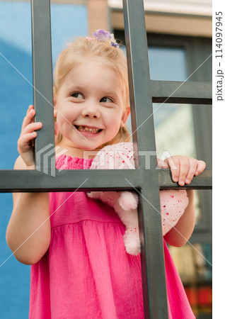 Happy cute child girl having fun outdoor in summer time. Children and generation alpha concept 114097945