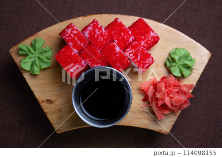 serve the roll with the sauce, wasabi and ginger on a wooden board kind of top serve the roll with the sauce, wasabi and ginger on a wooden board kind of top 114098155