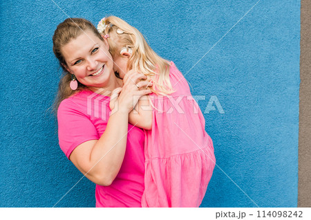 Blonde little girl with cochlear implant playing with her mother outdoor. Hear impairment deaf and health concept. Disability and inclusion. Copy space Blonde little girl with cochlear implant playing with her mother outdoor. Hear impairment deaf and health concept. Disability and inclusion. Copy space 114098242