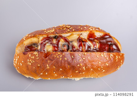 hot dog in a crispy bun with sesame seeds, mushrooms and sauce 114098291