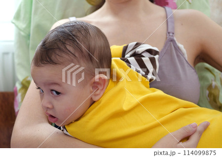 Young woman breastfeeding her baby at home. Milk from mother's breast is a natural medicine to baby. Mother day bonding concept with newborn baby nursing Young woman breastfeeding her baby at home. Milk from mother's breast is a natural medicine to baby. Mother day bonding concept with newborn baby nursing 114099875
