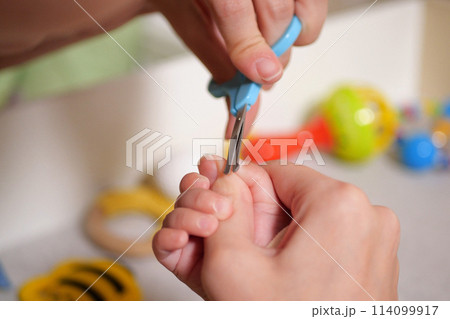 Cutting baby nails. Baby care, closed up shot of newborn nails clipping Cutting baby nails. Baby care, closed up shot of newborn nails clipping 114099917