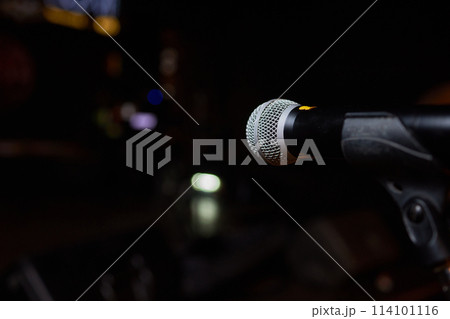 Microphone on stand before crowd, part of public address system at event 114101116