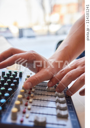 Hands playing buttons on an electronic keyboard mixer 114101241