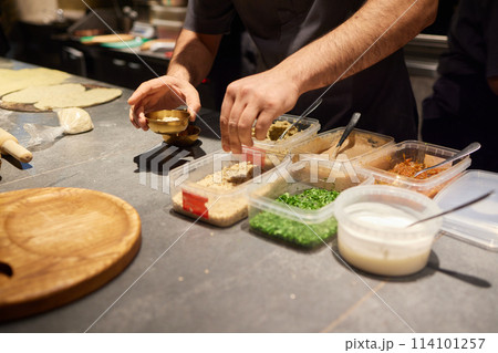 A group in the kitchen cook comfort food using ingredients for a delicious dish 114101257