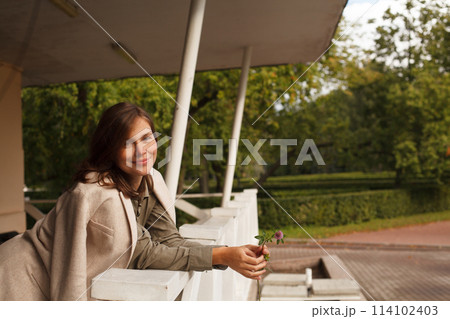 Attractive woman with brown hair and make-up resting outdoor 114102403