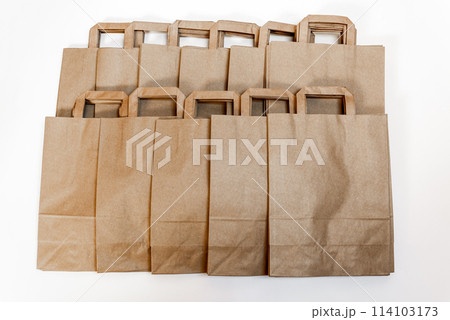 DISPOSABLE BAG OF KRAFT PAPER ON A WOODEN TABLE. RECYCLED SHOPPING PAPER BAG. DISPOSABLE BAG OF KRAFT PAPER ON A WOODEN TABLE. RECYCLED SHOPPING PAPER BAG. 114103173