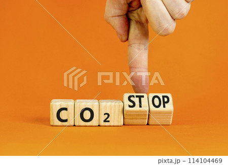 CO2 stop symbol. Concept word CO2 or CO2 stop on a beautiful wooden cubes. Beautiful orange table orange background. Businessman hand. Business ecological and CO2 stop concept. Copy space. 114104469
