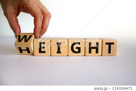 Male hand flips a wooden cube and changes the inscription 'height' to 'weight'. Beautiful white background, copy space. Business concept. 114104471